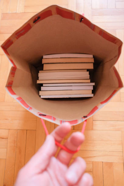 istock Human hand holding a bag full with books 1365119797