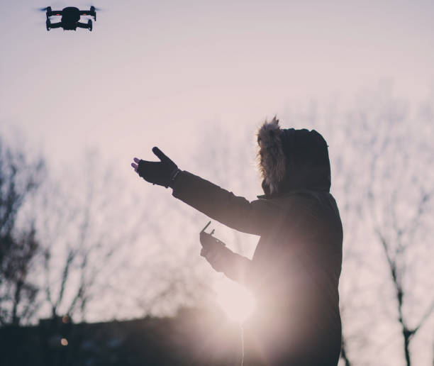 istock man with a flying drone at sunset 1365121294