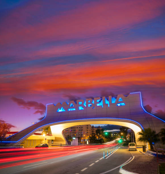 istock Marbella arch welcome sign at sunset with traffic light beams in 1365124070