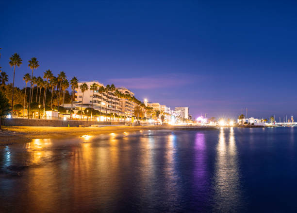 Marbella sunset beach in Playa del Faro Lighthouse beach in Malaga province of Spain with marina boats harbor.