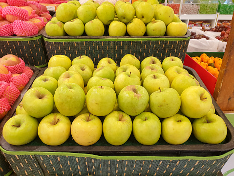 fresh green apples on the supermarket shelf.