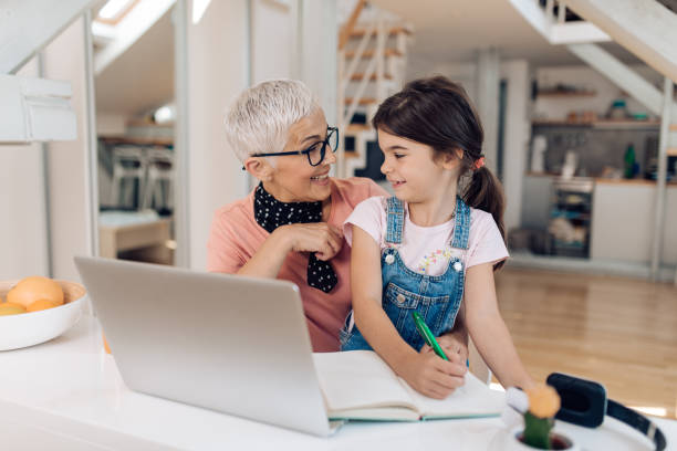 istock Girl helping her grandma while working and learning from her 1365128643