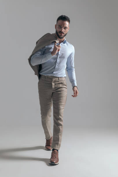 istock confident young man holding jacket over shoulder and walking 1365128707