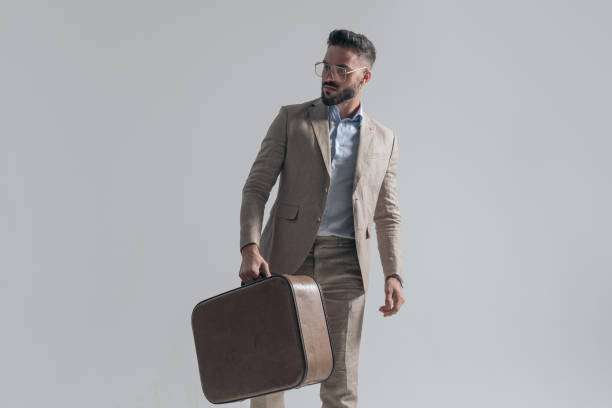 istock bearded young man in suit looking to side and holding briefcase 1365128902