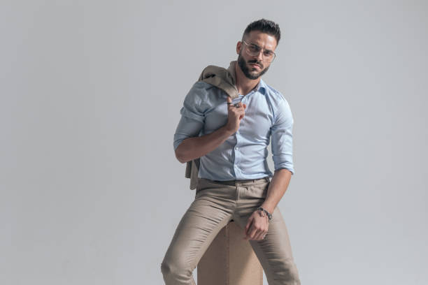 istock seductive bearded man with jacket over shoulder posing in a fashion way 1365129217