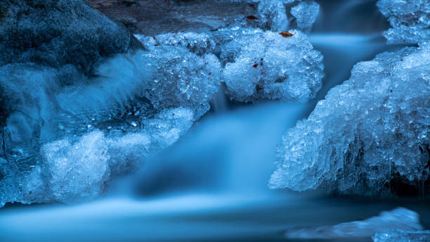 istock Long exposure of a beautiful frozen forest stream. 1365131376