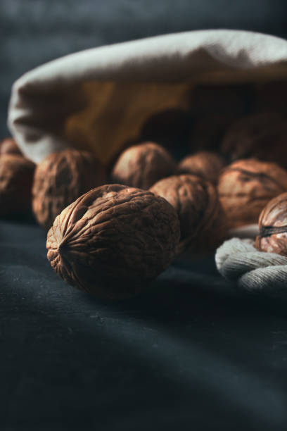 istock Sack of walnuts with copy space in dark mood shot. 1365131522
