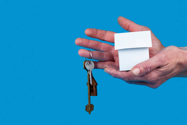 istock Hand with a toy house and keys. 1365133476