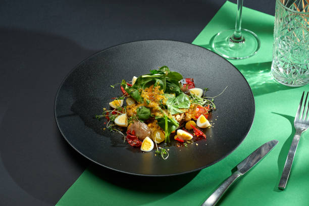istock Salad with chicken liver, citrus confit and eggs in a black plate. Colored backgrounds. Hard light. selective focus 1365134516