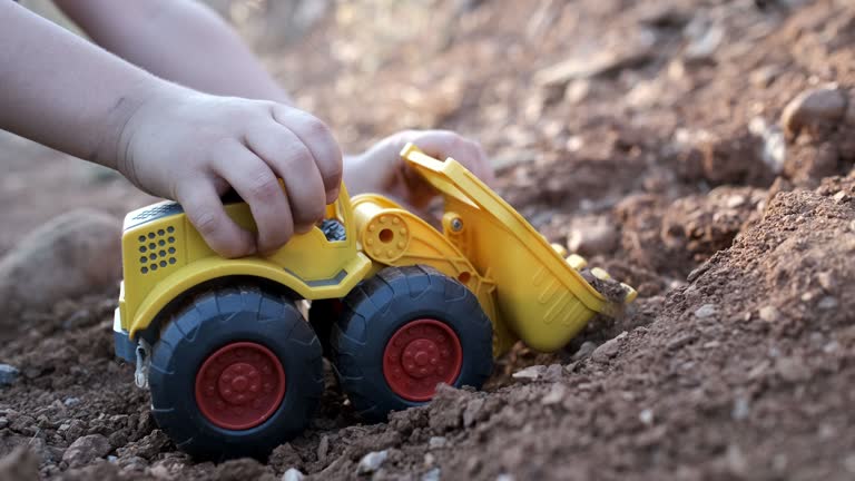 Little boy plays with toy earth mover