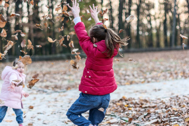 istock Children playing in autumn park 1365135140