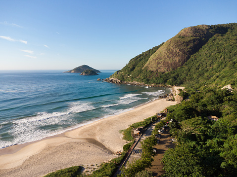 Vista aérea de la playa de Prainha, un paraíso en el lado oeste de Río de Janeiro, Brasil. Grandes colinas alrededor. Día soleado al amanecer. Mar verdoso. Foto de drone photo