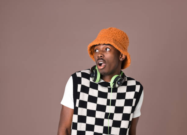 istock Surprised young man against brown background 1365136936