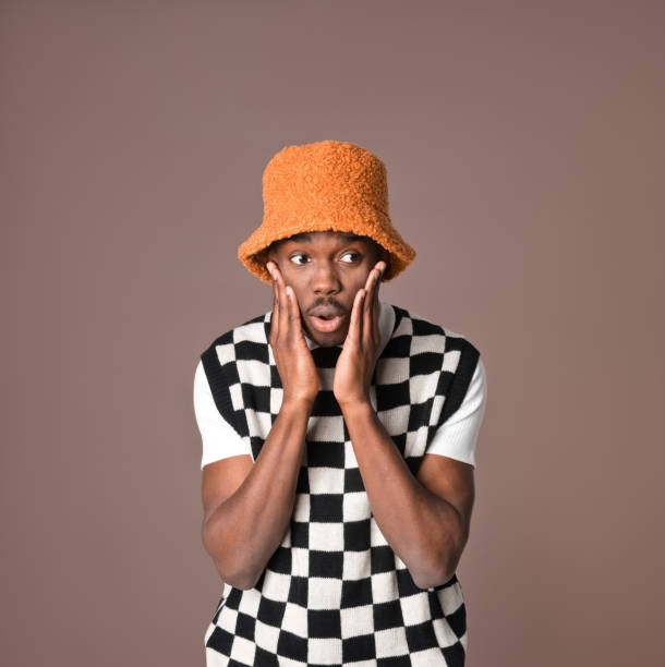 istock Surprised young man against brown background 1365137009