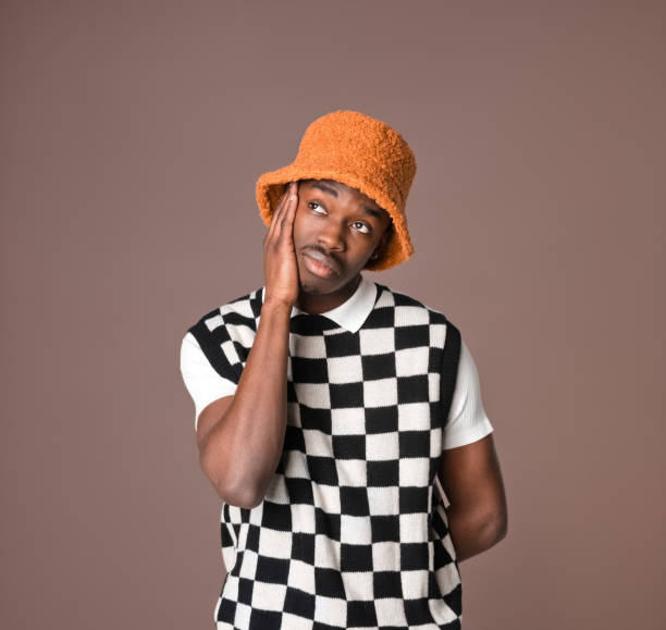 istock Worried young man against brown background 1365137087