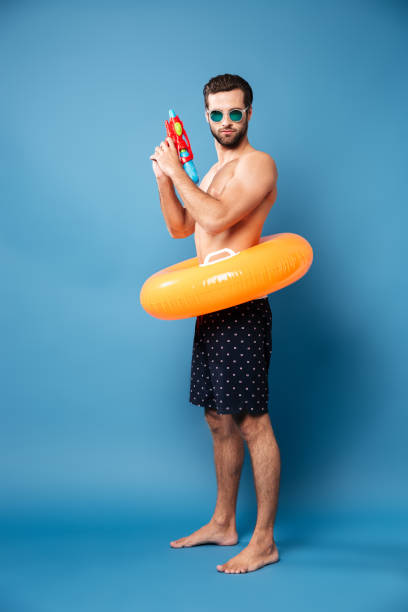 istock Serious man with water gun standing isolated 1365137188