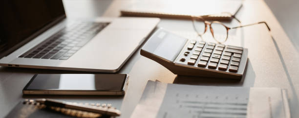 istock Workplace in office, calculator, laptop computer, glasses at office desk 1365137400