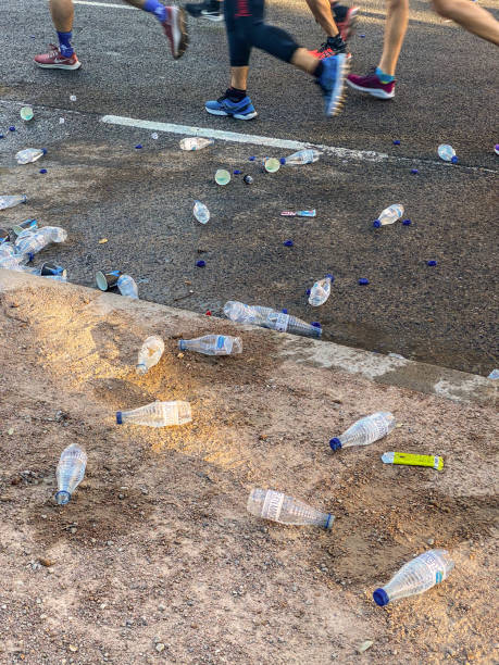 Valencia, Spain - December 5, 2021: Lots of plastic water bottles throne in the street. These are given to the runners so they hydrate while running without stopping the race. After they drink their contents they throw them back to the floor