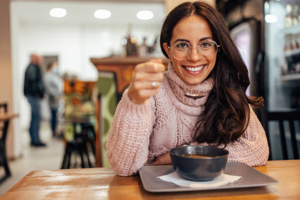 Smiling woman with glasses, eating at a restaurant and enjoying. stock photo