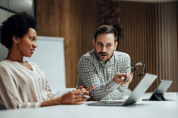 istock Smart caucasian man, teaching his new african-american employee about programming. 1365140749