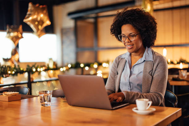 istock Smiling african-american woman, working even during her lunch break. 1365141975