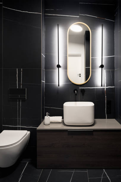 istock Stylish dark bathroom with black tiles 1365142117
