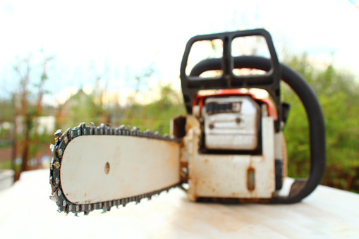 Chainsaw in the garden. Close-up. Blurred background.