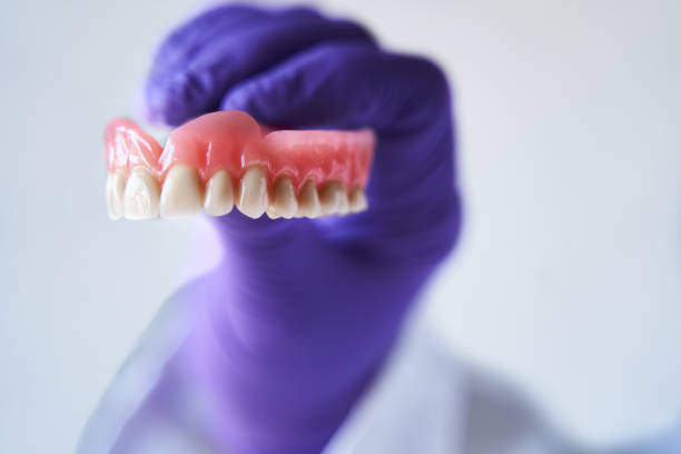 istock Close up false teeth in odonthologist hands. Dental healtcare insurance concept. 1365148840