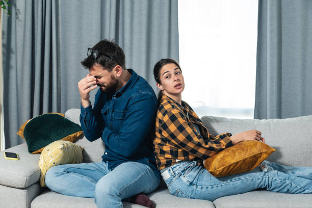 istock Young couple are arguing on the couch in their home and having difficulty and problems in a relationship and marriage sitting back to back ignoring and not talking to each other, relationship problems 1365149417