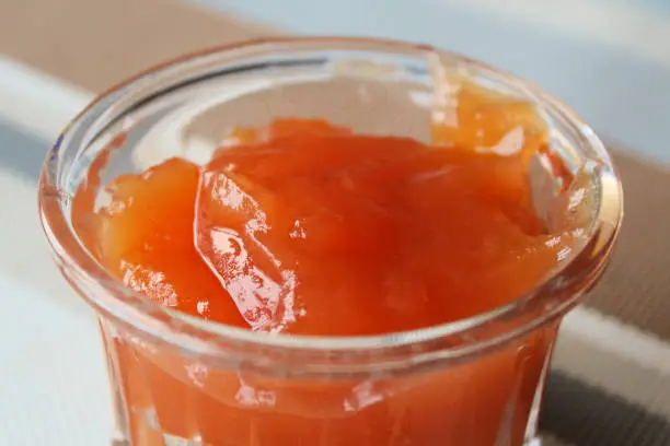 Fresh applesauce in a glass jar. Close-up. Background.