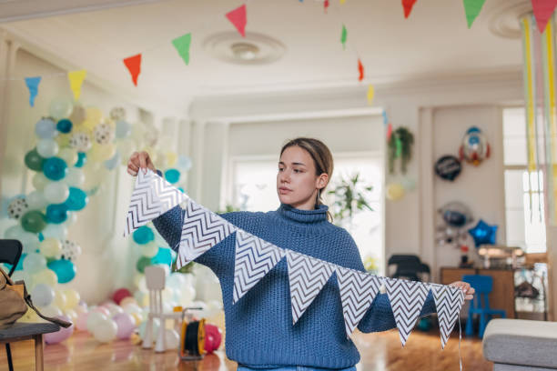 istock Young  decorator hanging party flags and preparing room for celebration 1365152715