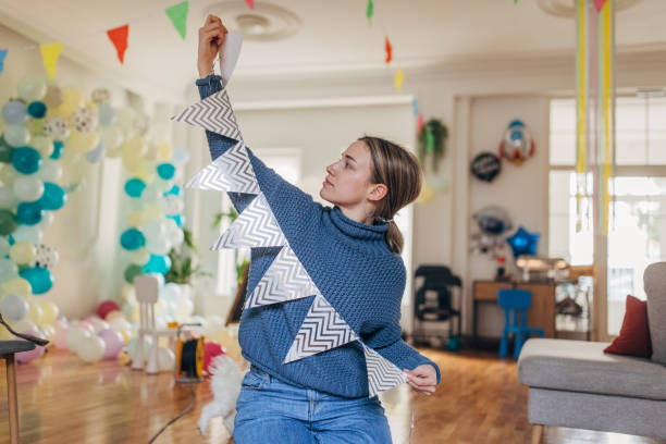istock Young  decorator hanging party flags and preparing room for celebration 1365152824