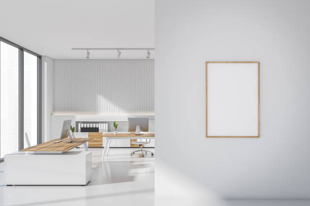 istock Bright office room interior with empty white poster, two desks 1365154096