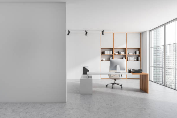 istock Bright office room interior with empty white wall, desk, armchair 1365154464