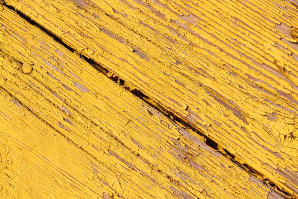 Old boards with yellow paint. Background. Close-up.