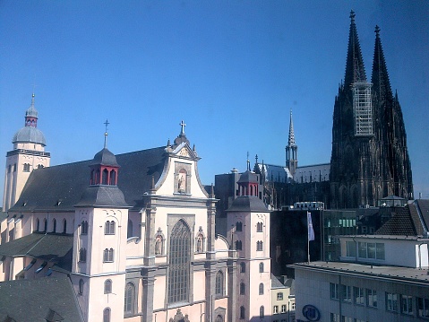Cathedral of Cologne Germany in gothic style with typical German houses on a sunny blue sky
