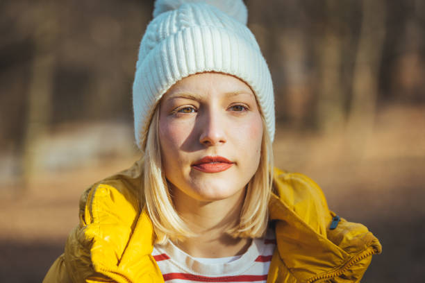 Portrait of a young cheerful girl in a hat during a walk in a sunny autumn park