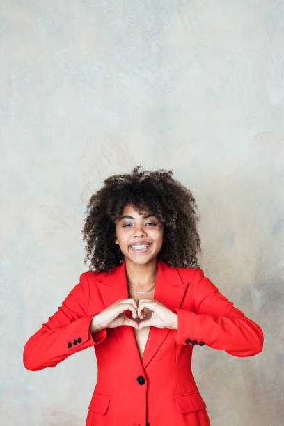 istock Cheerful young woman wearing red blazer 1365156186