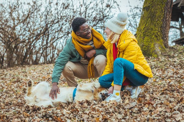 istock Couple with pet dog relaxing while hiking at forest 1365156187