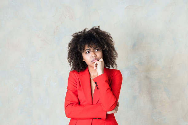 istock Thoughtful young woman wearing red blazer 1365157730