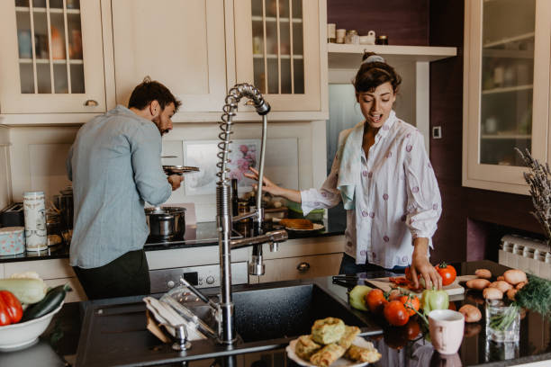 istock Young parents in the kitchen preparing pasta together 1365158772