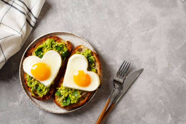 istock Healthy breakfast with eggs hearts and cup of coffee on grey background 1365158922