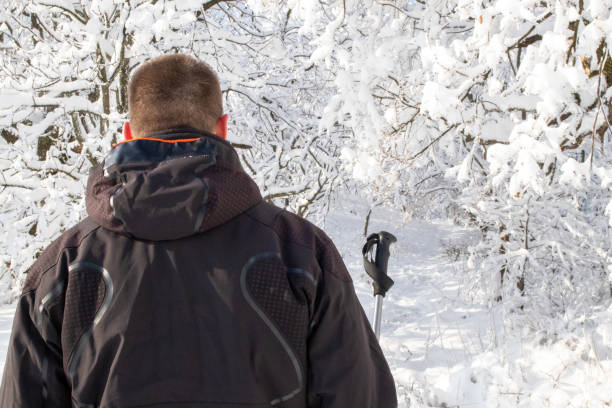 istock Man hiking through snowy forest 1365165080
