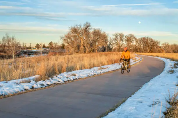 one of numerous bike trails in Fort Collins, Colorado, winter scenery with a male cyclist on a touring bike