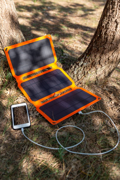 istock Smartphone is charging from solar battery in summer camp. 1365171043