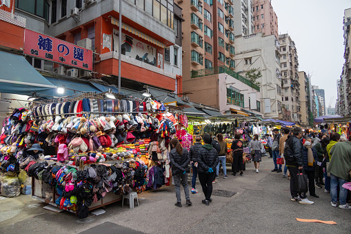 Hong Kong - January 17, 2022 : People at Fa Yuen Street, Mong Kok, Kowloon, Hong Kong. Many street vendors selling products on the road between the buildings.