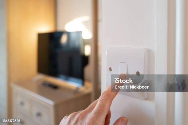 Shallow Focus Of A Home Owner Switching Off A Bedroom Light After Waking Up In Late Morning Stock Photo - Download Image Now