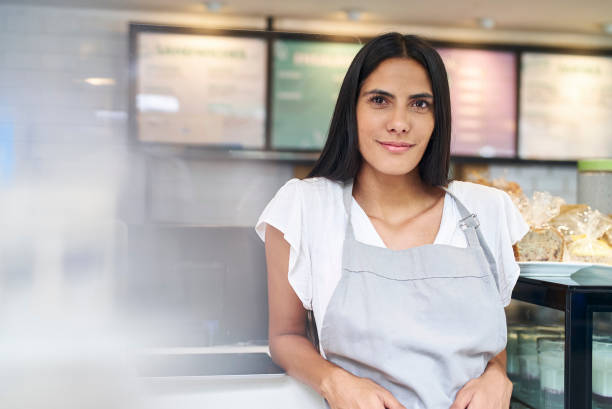 istock Cake shop female owner leaning on counter while looking at the camera 1365172398
