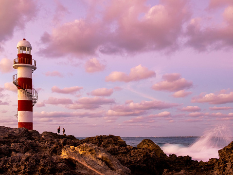 Two tourists watching the sunset at the Cancun ligthhouse