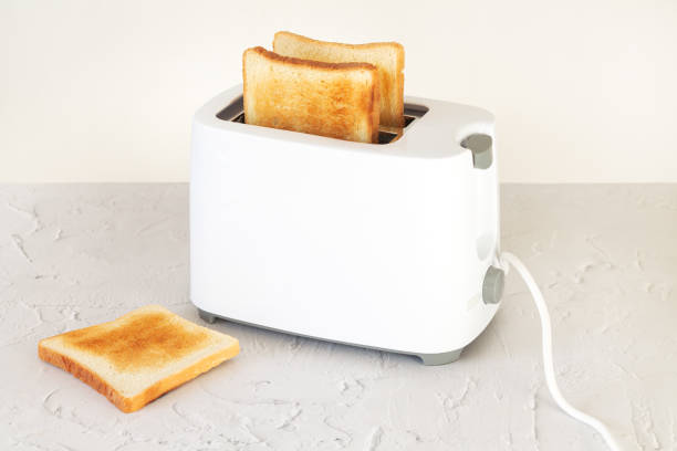 istock Sliced toasted toast bread for breakfast in toaster on kitchen table 1365173834